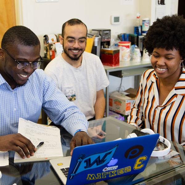 Wilkes students talking while using a laptop